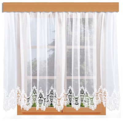 Ein Fenster mit Holzverkleidung ist mit den transparenten weißen Vorhängen von Edler Spitzen-Store geschmückt. Die Vorhänge haben eine aufwendige Spitzenverzierung entlang der unteren Kante, die sogenannte Spitzenkante, die für eine elegante Note sorgt. Durch das Fenster ist ein Blick auf das Grün von draußen zu sehen.