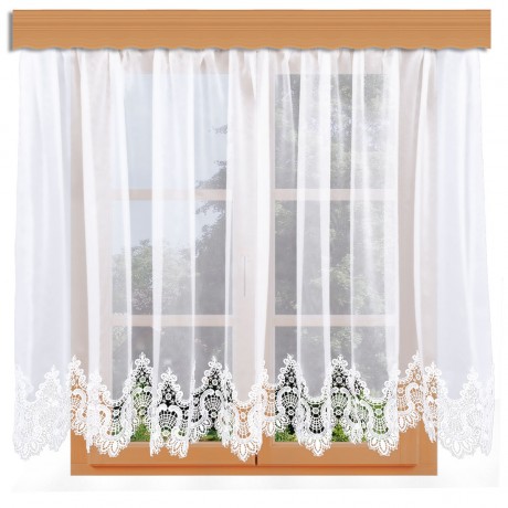 Ein Fenster mit Holzverkleidung ist mit den transparenten weißen Vorhängen von Edler Spitzen-Store geschmückt. Die Vorhänge haben eine aufwendige Spitzenverzierung entlang der unteren Kante, die sogenannte Spitzenkante, die für eine elegante Note sorgt. Durch das Fenster ist ein Blick auf das Grün von draußen zu sehen.