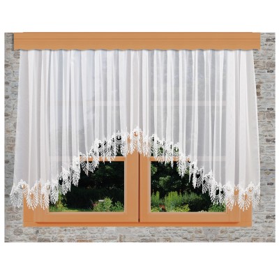 Ein halblanges Fenster mit orangefarbenem Holzrahmen ist mit einem weißen Spitzenvorhang Nastja geschmückt, der an der Unterkante ein aufwendiges Blumenmuster aufweist. Im Hintergrund ist eine Steinmauer zu sehen und durch das Glas ist ein grüner Garten zu sehen.