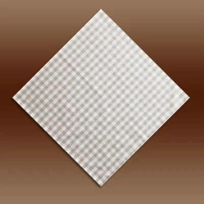 Eine beige-weiß karierte Serviette ist rautenförmig vor einem braunen Hintergrund mit Farbverlauf angeordnet.