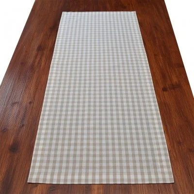 Ein Holztisch mit einem beige-weiß karierten Tischläufer 100 cm lang, der längs in der Mitte verlegt ist.