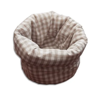 Ein runder, weicher Stoffkorb mit beige-weißem Karomuster, breitem, gefaltetem Rand und offenem Deckel, abgebildet auf weißem Hintergrund.