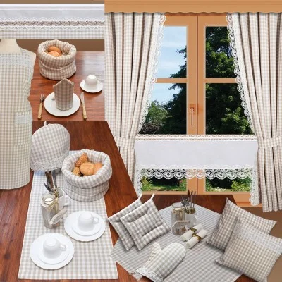 Eine gemütliche Küche mit beige-weiß karierten Vorhängen, passender Tischwäsche, Brotkörben, Servietten und Kissen, alles auf einem Holztisch am Fenster mit Blick auf grüne Bäume. Weiße Spitzenbordüren verzieren den Stoff.