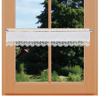 Ein holzgerahmtes Fenster mit einer Glasscheibe gibt den Blick auf einen üppigen grünen Garten frei. An einer Stange über der unteren Hälfte des Fensters hängt ein weißer Spitzen-Cafévorhang mit Wellenkanten und Blumenmuster.