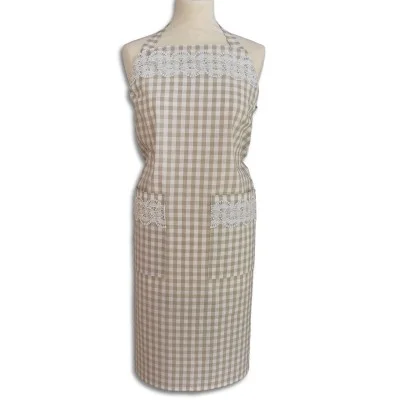 Eine beige-weiß karierte Schürze mit zwei Vordertaschen und Spitzenbesatz am Oberteil und den Taschen ist auf einer Kleiderform vor weißem Hintergrund ausgestellt. Die Schürze hat einen Nackenriemen und bedeckt den Oberkörper und die Oberschenkel.