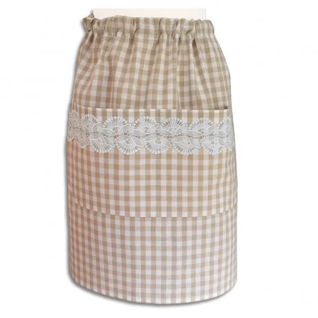 Eine knielange Schürze mit beige-weißem Gingham-Muster und einer großen Tasche auf der Vorderseite. Quer über die Tasche verläuft ein dekorativer Streifen aus weißer Spitze mit Blumenmuster. Die Schürze hat einen gerafften Bund und ist vor einem weißen Hintergrund zu sehen.