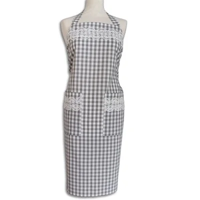 Eine Schaufensterpuppe trägt eine grau-weiß-karierte Schürze mit zwei Vordertaschen. Die Schürze hat eine weiße Spitzenborte über der Brust und an den Taschenoberseiten. Die Schürze ist im Nacken und in der Taille zu binden und reicht von der Brust bis unterhalb der Knie.