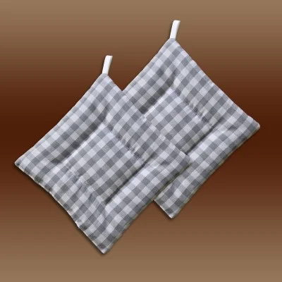Zwei grau-weiß karierte Topflappen aus Stoff mit Schlaufen, die sich leicht überlappen, auf einem Hintergrund mit braunem Farbverlauf.