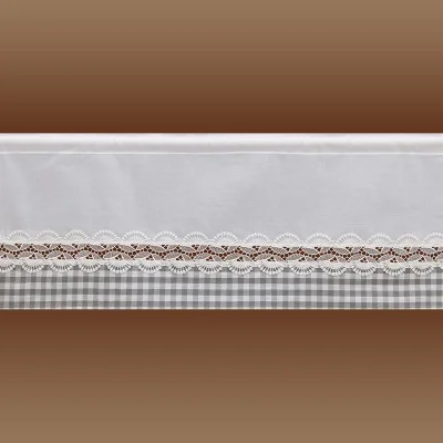 Nahaufnahme eines weißen Stoffes mit einer dekorativen Spitzenborte und einem Wellenrand. Unterhalb der Spitze befindet sich ein grau-weißes Karomuster. Der Hintergrund ist ein brauner Farbverlauf.