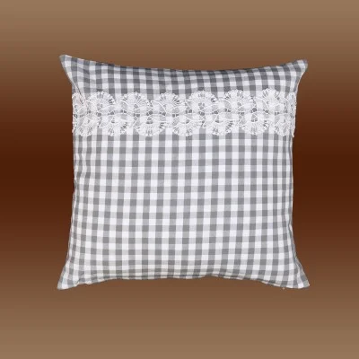 Ein quadratisches Kissen mit grau-weißem Karomuster, verziert mit einem horizontalen Streifen weißer Spitze, auf einem Hintergrund mit braunem Farbverlauf.