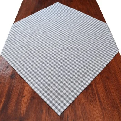 Grau-weiß kariertes, sechseckiges Tischtuch auf einem dunklen Holztisch.