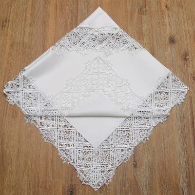 Ein weißes Taschentuch mit aufwändiger Spitzenbordüre und einem dekorativen Spitzenmuster wird rautenförmig gefaltet und auf eine Holzunterlage gelegt. Die Spitze weist detaillierte geometrische und florale Elemente auf.