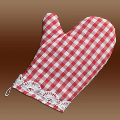 Ein rot-weiß karierter Ofenhandschuh mit Spitzenbesatz am Handgelenk, der flach auf einem braunen Hintergrund mit Farbverlauf liegt.