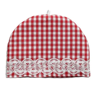 Ein Teewärmer mit rot-weißem Karomuster und einem Streifen dekorativer weißer Spitze am unteren Rand auf weißem Hintergrund.