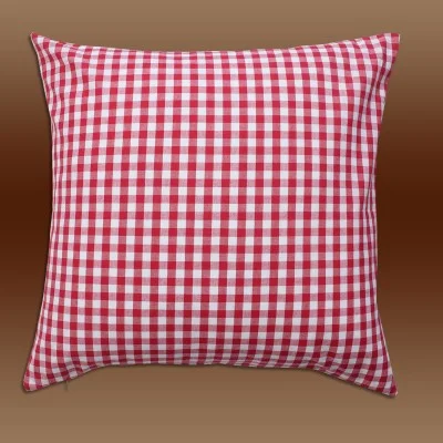 Ein quadratisches Kissen mit einem rot-weiß karierten Muster auf einem braunen Hintergrund mit Farbverlauf.
