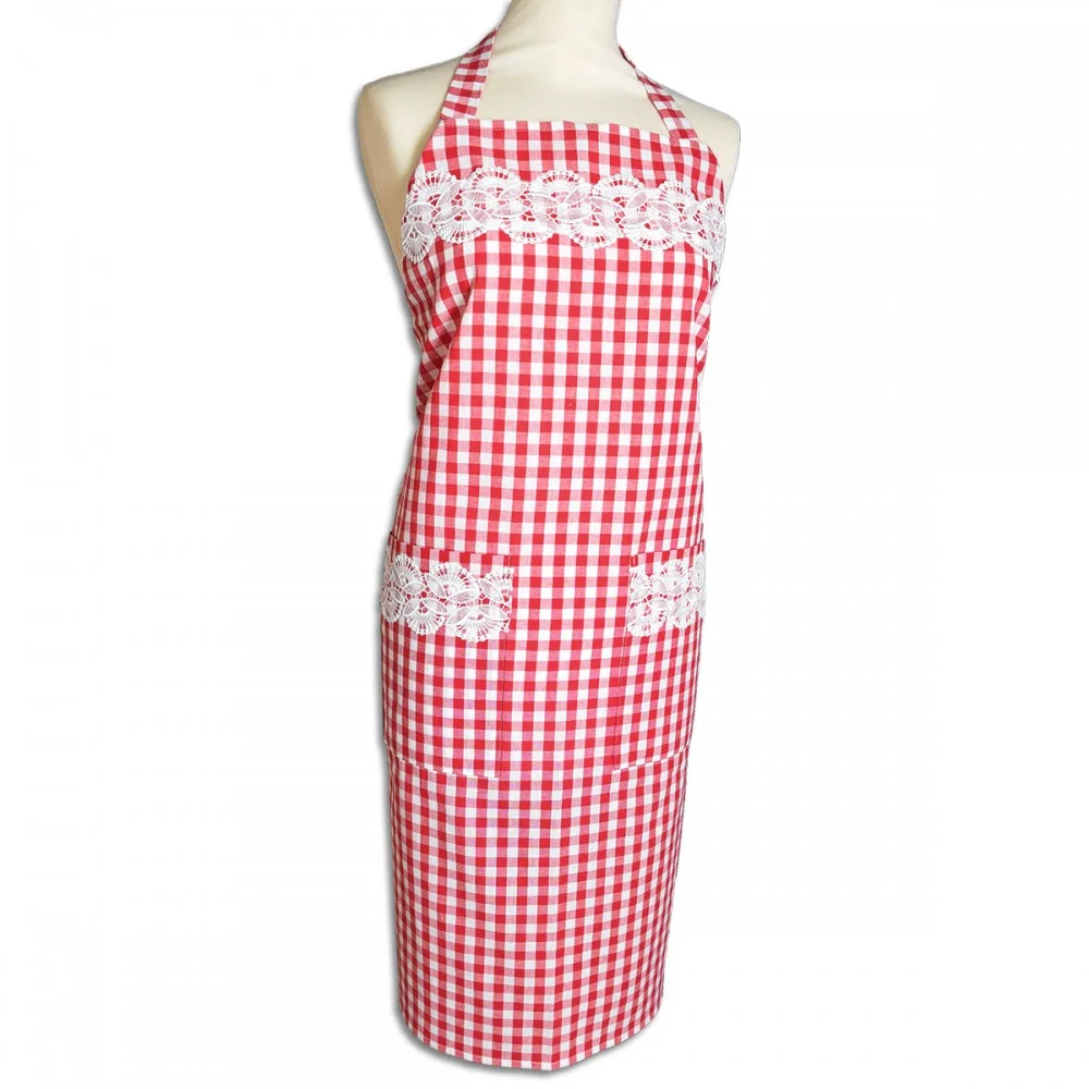 Eine Schaufensterpuppe trägt eine rot-weiß karierte Schürze mit einem Neckholder. Die Schürze ist mit weißer Spitze über der Brust und über zwei Vordertaschen verziert. Das Kleidungsstück ist ganz lang und reicht von der Brust bis zu den Knien.