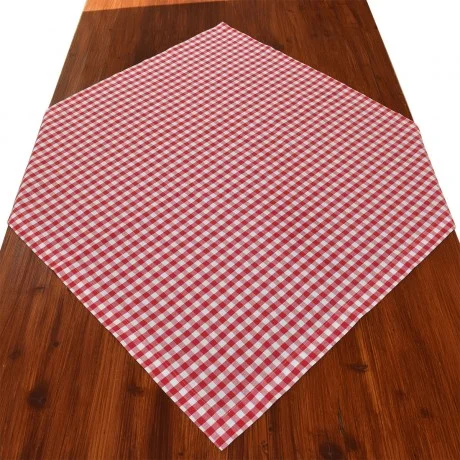 Ein rot-weiß kariertes Tischtuch mit Rautenmuster ist auf einem Holztisch ausgebreitet.