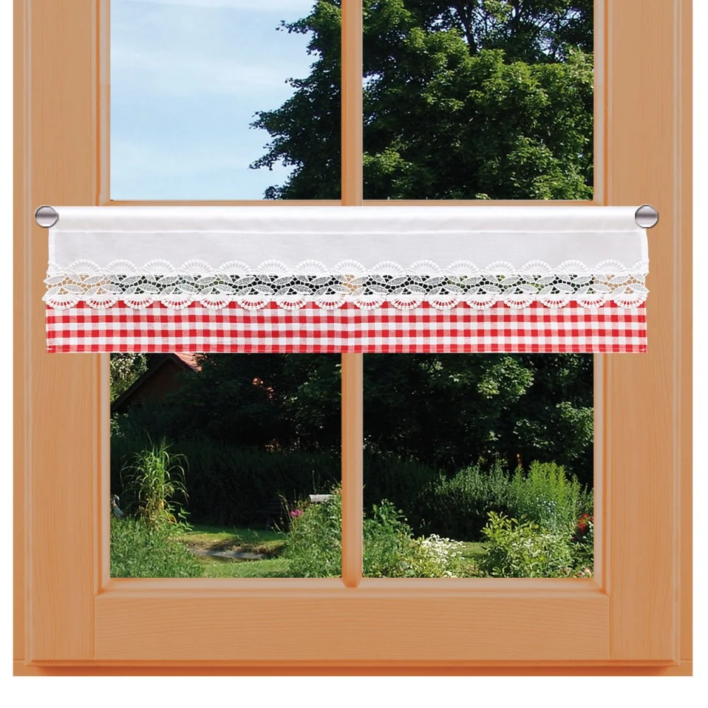 Ein holzgerahmtes Fenster mit einem kurzen Cafévorhang aus rot-weißem Gingham-Stoff, weißer Spitzenborte und einem weißen Paneel. Draußen sind üppiges Grün, Bäume, Pflanzen und ein Teil eines Hauses mit schrägem Dach zu sehen.