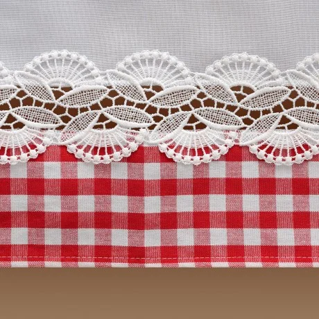 Nahaufnahme eines Stoffes mit weißer Spitzenborte über einem rot-weiß karierten Muster und einem braunen Streifen am unteren Rand. Die Spitze weist ein florales Wellenmuster auf, das im Kontrast zu den sauberen, kräftigen Karos des Gingham-Stoffes steht.