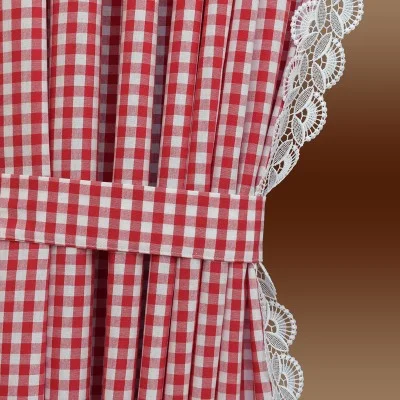 Rot-weiß karierter Vorhang mit passendem Raffhalter aus Stoff und weißer Spitzenborte am Rand vor einem Hintergrund mit braunem Farbverlauf.
