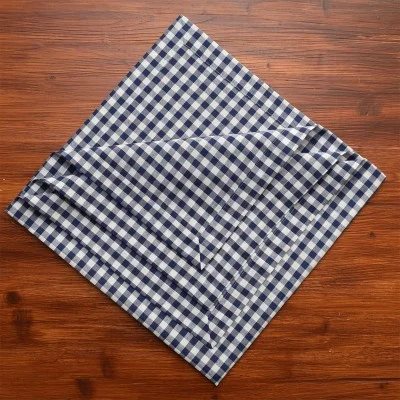 Eine blau-weiß karierte Serviette auf einer Holzfläche.