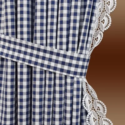 Ein blau-weiß karierter Vorhang, der nach hinten gebunden wird, mit weißer Spitzenborte am Rand, vor einem Hintergrund mit braunem Farbverlauf.