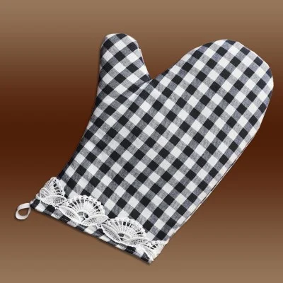 Ein schwarz-weiß karierter Topfhandschuh mit Spitzenbesatz und einer kleinen Schlaufe zum Aufhängen, dargestellt auf einem braunen Hintergrund mit Farbverlauf.