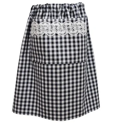 Eine schwarz-weiß karierte Schürze mit einer großen Tasche auf der Vorderseite. Die Tasche ist mit einem horizontalen Streifen aus weißer Spitze mit Blumenmuster verziert. Der Bund ist mit einem Gummiband gerafft und lässt sich verstellen.