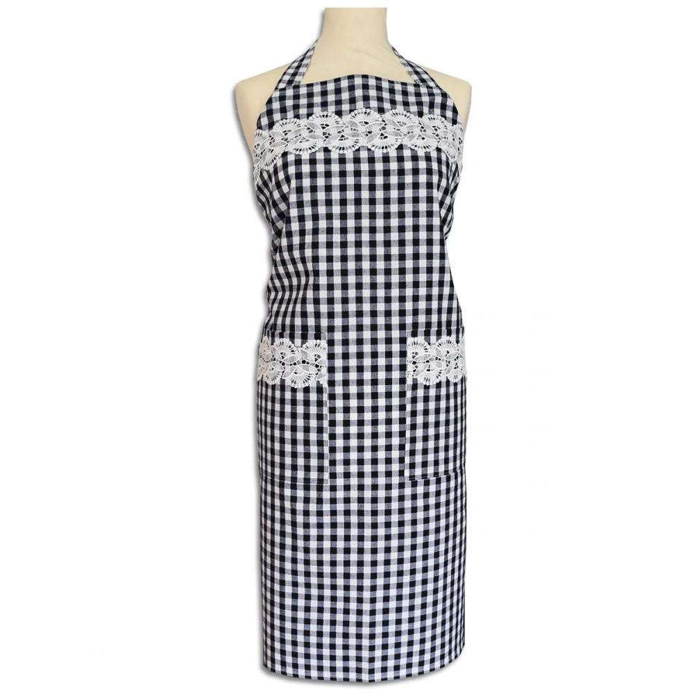 Eine Schaufensterpuppe trägt eine schwarz-weiß-karierte Schürze mit zwei Vordertaschen. Die Schürze ist mit weißer Spitze auf der Brust und an den Taschenoberseiten verziert. Das Nackenband ist ebenfalls kariert, und die Schürze reicht von der Brust bis zu den Knien.