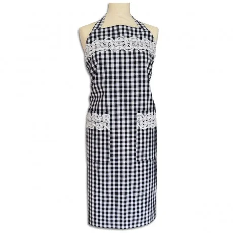 Eine Schaufensterpuppe trägt eine schwarz-weiß-karierte Schürze mit zwei Vordertaschen. Die Schürze ist mit weißer Spitze auf der Brust und an den Taschenoberseiten verziert. Das Nackenband ist ebenfalls kariert, und die Schürze reicht von der Brust bis zu den Knien.
