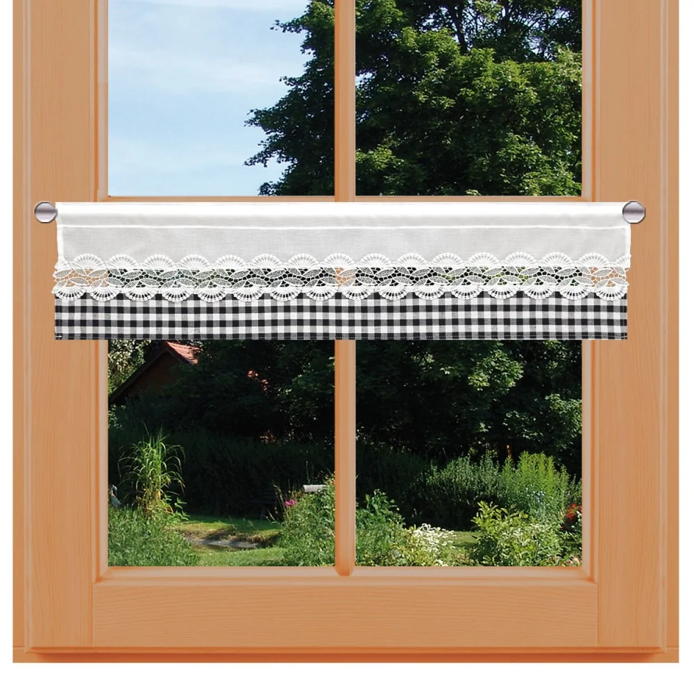 Ein holzgerahmtes Fenster mit einem kurzen Vorhang, der an einer kleinen Stange aufgehängt ist. Der Vorhang ist oben mit weißer Spitze und unten mit einem schwarz-weiß-karierten Muster versehen, das den Blick auf einen Garten mit grünem Gras, Büschen und Bäumen freigibt.