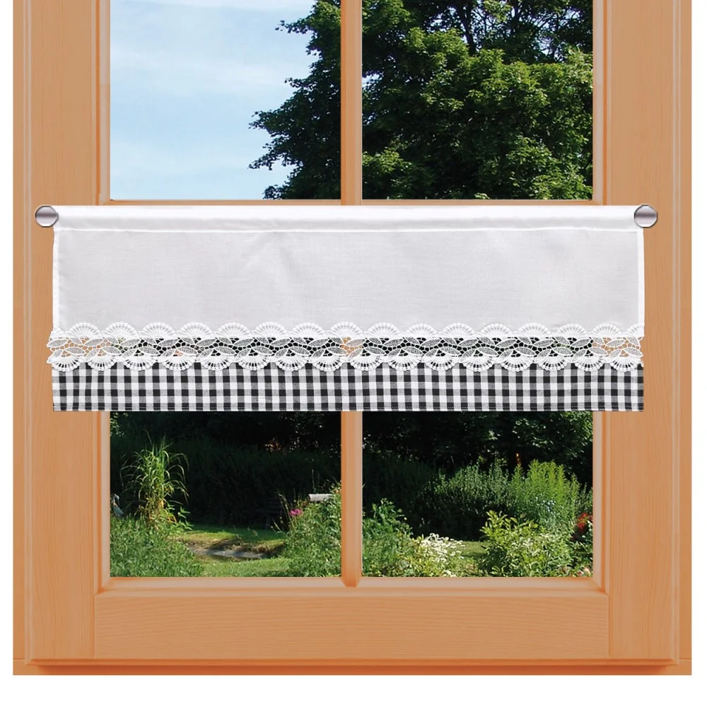 Ein Fenster mit einem hellen Holzrahmen zeigt einen Garten und Bäume. Das Fenster hat einen kurzen Vorhang: die obere Hälfte ist einfarbig weiß, die untere Hälfte ist mit schwarz-weißer Gingham und einem Streifen weißer Spitze versehen und hängt an einer Stange in der Mitte des Fensters.