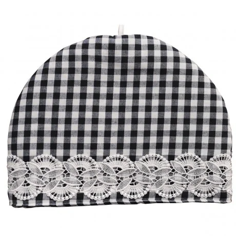 Ein schwarz-weiß karierter Teewärmer mit abgerundeter Oberseite. Der untere Rand ist mit einem breiten Streifen weißer Spitze mit floralem Muster verziert. In der oberen Mitte ist eine kleine weiße Schleife angebracht. Der Hintergrund ist einfarbig und weiß.