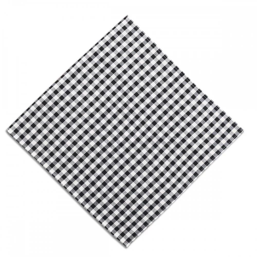 Eine sauber gefaltete, quadratische Serviette mit einem schwarz-weiß karierten Muster auf weißem Hintergrund, die diagonal angeordnet ist.