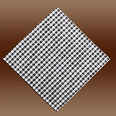 Eine sauber gefaltete quadratische Stoffserviette mit einem schwarz-weiß karierten Muster, das diagonal auf einem braunen Hintergrund mit Farbverlauf dargestellt ist.
