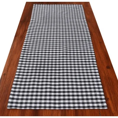Ein schwarz-weiß karierter Tischläufer ist auf einem Holztisch ausgebreitet.