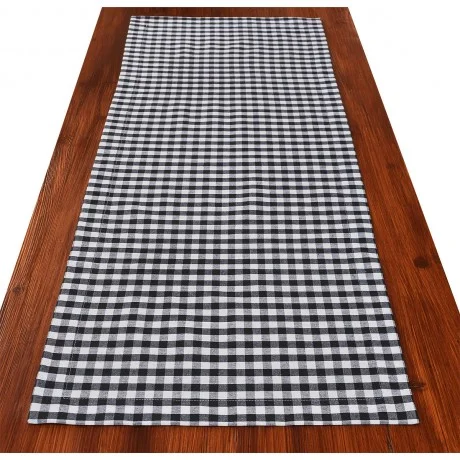Ein schwarz-weiß karierter Tischläufer ist auf einem Holztisch ausgebreitet.