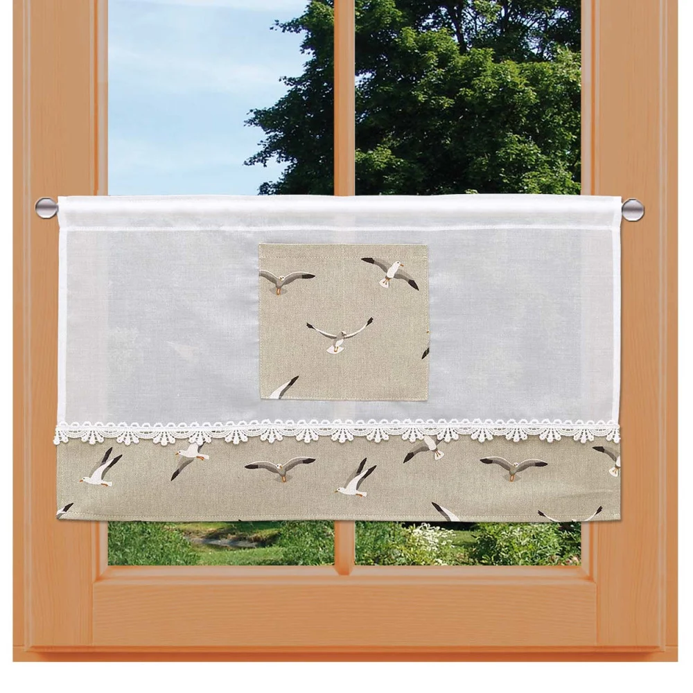 Ein Fenster mit Holzrahmen und einer kurzen Gardinenbahn. Der Vorhang hat einen weißen oberen Teil mit Spitzenbesatz und einen beigen unteren Teil, der mit einem Möwenmuster verziert ist. Außerhalb des Fensters sind ein grüner, belaubter Baum und ein blauer Himmel zu sehen.