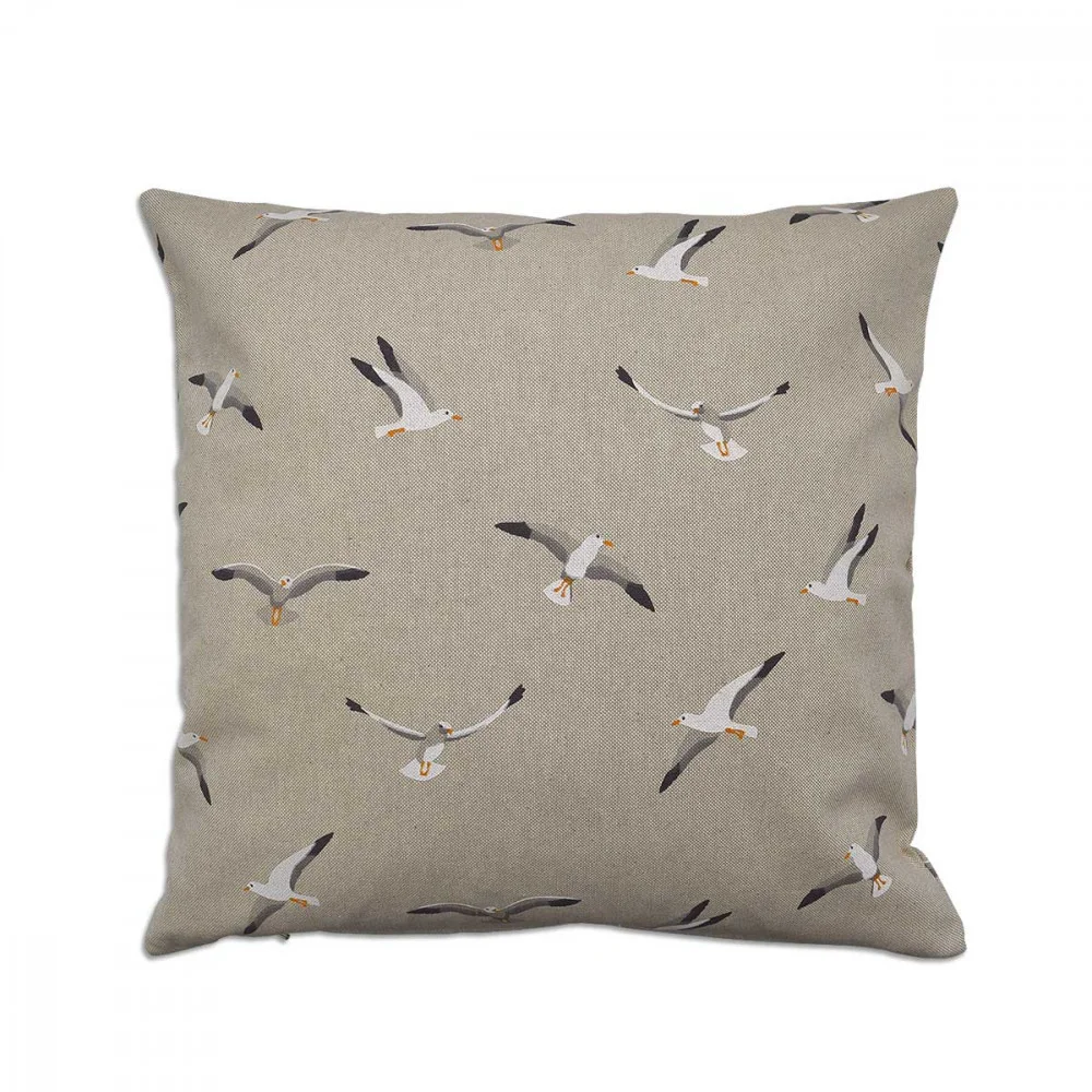 Quadratisches beiges Kissen mit einem einheitlichen Muster aus weißen und grauen Möwen in verschiedenen Flugpositionen. Jeder Vogel hat orangefarbene Schnäbel und Füße. Der Hintergrund ist einfarbig, und das minimalistische Muster ist gleichmäßig über den gesamten Stoff verteilt. Größe 40 x 40 cm