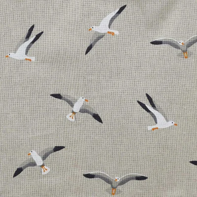 Der beigefarbene Stoff zeigt ein sich wiederholendes Muster aus illustrierten Möwen im Flug. Die Möwen haben einen weißen Körper, graue Flügel mit schwarzen Spitzen und orangefarbene Schnäbel und Füße. Sie sind in verschiedenen Winkeln auf einem subtil strukturierten Hintergrund ausgerichtet.