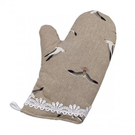 Ein beiger Topfhandschuh mit einem dezenten Gittermuster ist mit fliegenden Möwen verziert. Der Handschuh hat eine weiße Spitzenborte am Handgelenk und eine kleine weiße Aufhängeschlaufe an der unteren Ecke.