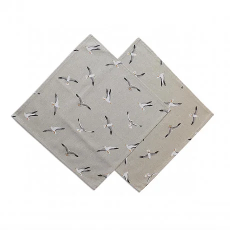 Zwei sich überlappende quadratische Stoffservietten mit beigem Hintergrund zeigen ein einheitliches Muster aus fliegenden Möwen in verschiedenen Positionen. Jede Serviette hat sauber gesäumte Ränder, und das Vogelmotiv ist gleichmäßig über den Stoff verteilt.