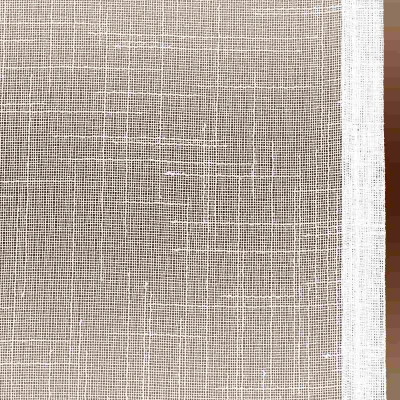 Eine Nahaufnahme eines weißen Gewebes mit grober Textur. Das Material scheint ein gitterartiges Muster aufzuweisen, das durch die sich kreuzenden Fäden entsteht. Am rechten Rand ist ein weißer Rand zu sehen, der vertikal entlang des Stoffes verläuft.