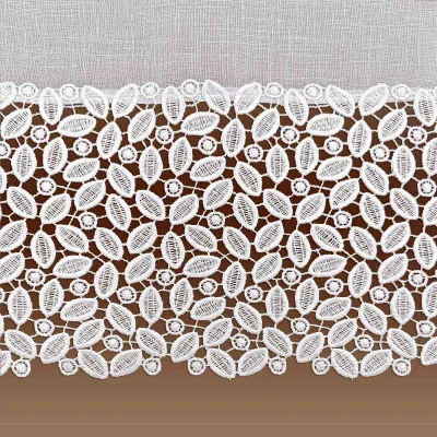 Eine Nahaufnahme eines Stücks aufwendiger weißer Spitze mit einem floralen und kreisförmigen Muster. Die Spitze befindet sich auf einem hellen, strukturierten Hintergrund. Das Design ist detailliert, mit ovalen und runden Formen, die in einer sich wiederholenden Anordnung verbunden sind.