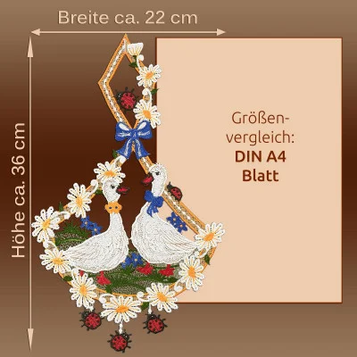 Spitzenbild mit zwei weißen Gänsen, umgeben von Gänseblümchen und Marienkäfern, die den Charme einer Landhaus-Idylle einfangen. Das Stickmuster im Stil der Vogtländischen Spitze misst 36 cm x 22 cm und hebt sich wunderschön vor einem braunen Hintergrund neben einem DIN A4-Blatt ab.
