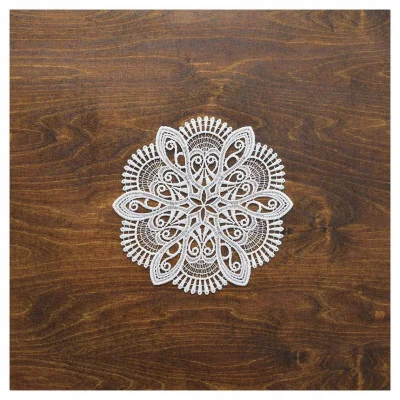 Ein weißes, aufwendig gemustertes, rundes Deckchen aus vogtländischer Spitze und einem Blumendesign ist auf einer dunkelbraunen Holzoberfläche zentriert und bildet eine elegante Tischdekoration.