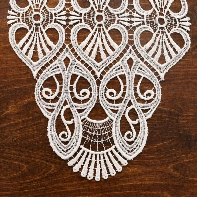 Naturfarbenes Spitzendeckchen, inspiriert von der Vogtländischen Spitze, mit einem filigranen, symmetrischen Muster auf einer dunklen Holzoberfläche. Dieses Deckchen eignet sich perfekt als Tischdekoration und besticht durch Wirbel, Schleifen und zarte Stickereien.