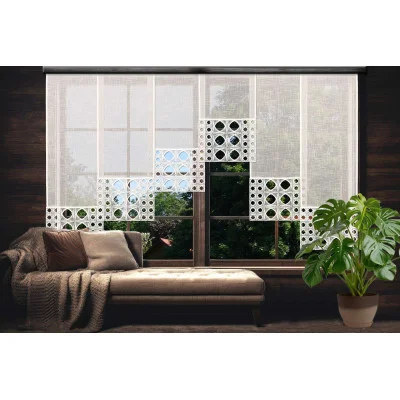 Ein gemütlicher Raum mit einer beigen Chaiselongue, einer Strickdecke und Kissen neben einem Fenster mit dekorativen cremefarbenen Flächengardinen. Draußen sind grüne Bäume zu sehen. Rechts steht eine Monstera-Topfpflanze.