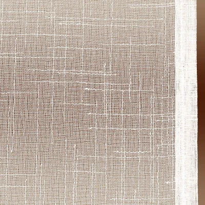 Eine Nahaufnahme eines sektfarbenen Gewebes mit grober Textur. Das Material scheint ein gitterartiges Muster aufzuweisen, das durch die sich kreuzenden Fäden entsteht. Am rechten Rand ist ein sektfarbener Rand zu sehen, der vertikal entlang des Stoffes verläuft.