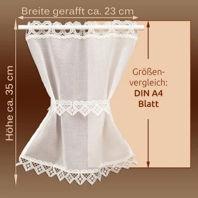Kleiner weißer Spitzenvorhang auf einer Stange, mit den Maßangaben ca. 23 cm Breite und 35 cm Höhe. Der Hintergrund vergleicht die Vorhanggröße mit einem A4-Blatt.